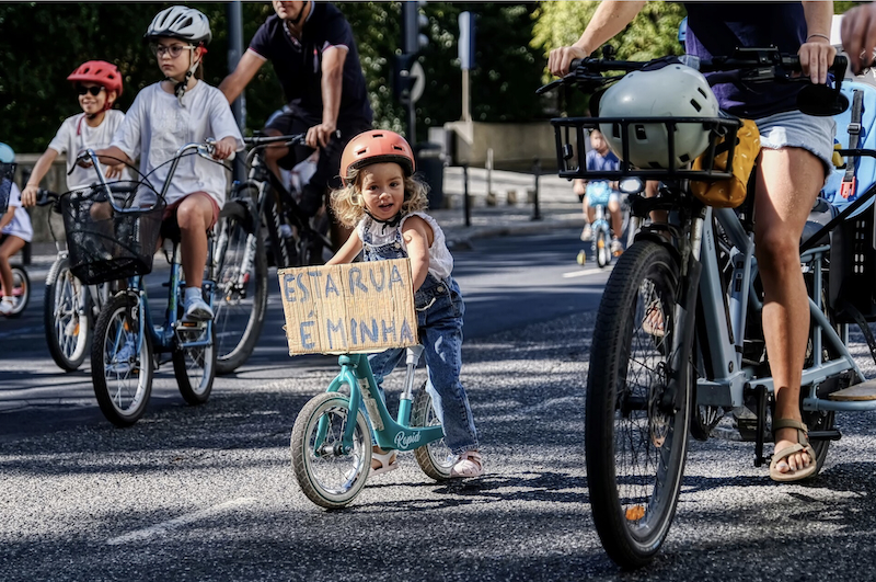 Famílias e crianças a pedalar numa rua de Lisboa durante a Kidical Mass